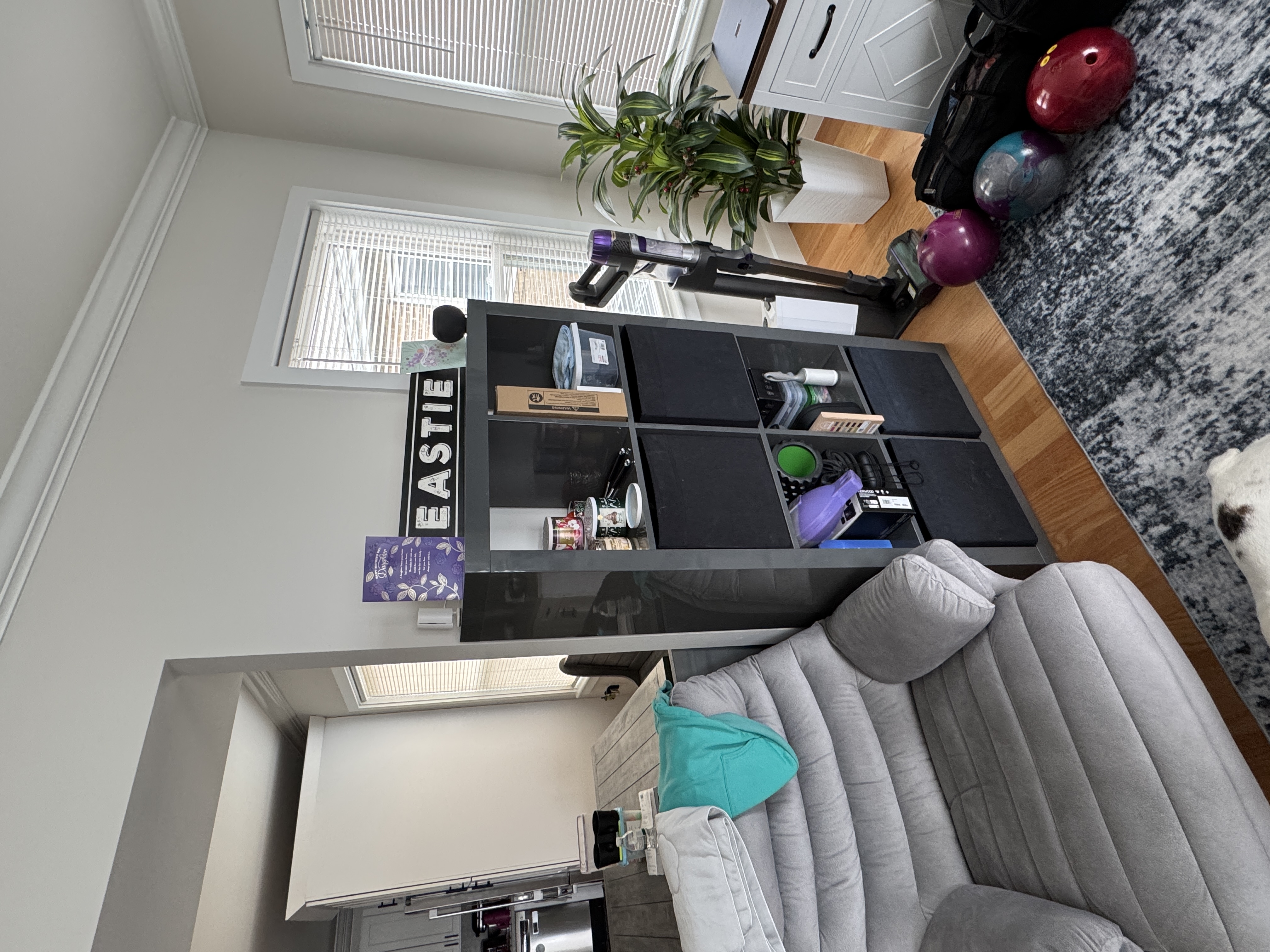 IKEA bookcase in the living room with objects that can be moved onto chairs.